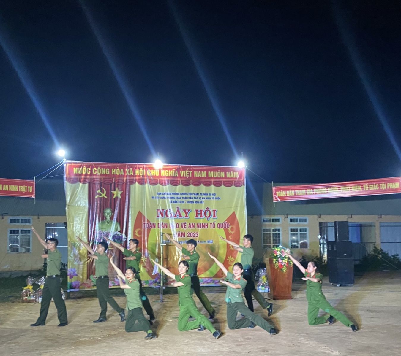 A group of people in green uniforms performing a dance  Description automatically generated